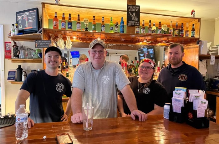 Image of firefighters behind a bar.